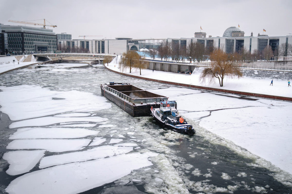 Ein Schubverband bahnt sich bei frostigen Temperaturen den Weg durch das Eis auf der Spree im Berliner Regierungsviertel. Auch in den kommenden Tagen bleibt es in der Hauptstadt eiskalt.