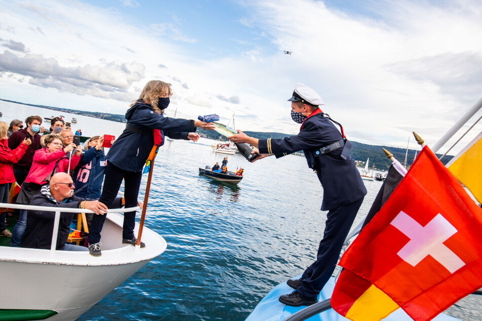 Besatzungsmitglieder der Passagierschiffe "Alet" (links) und "Stadt Radolfzell" (rechts) tauschen während einer Sternfarht auf dem Bodensee Geschenke aus.