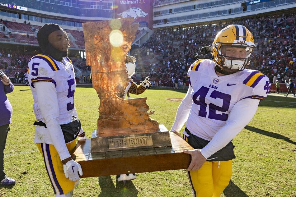 Jay Ward and Lane Blue of the LSU Tigers carry The Boot trophy off the field after defeating Arkansas and clinching a berth to the SEC conference championships.