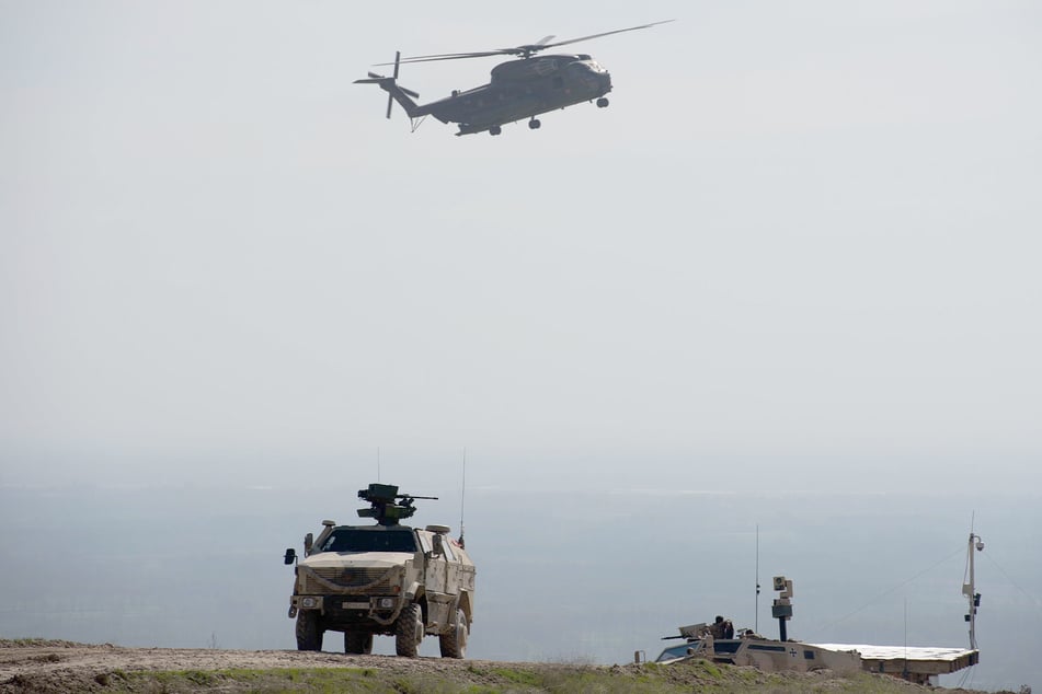 Ein Hubschrauber CH53 der Bundeswehr fliegt bei Masar-i-Scharif in Afghanistan über einen Dingo.