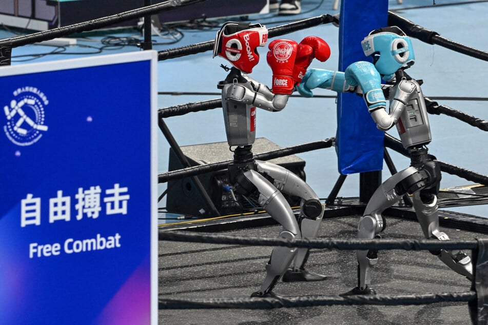 Robots demonstrate the sport of boxing during the opening ceremony of the World Humanoid Robot Games in Beijing, China, on August 14, 2025.