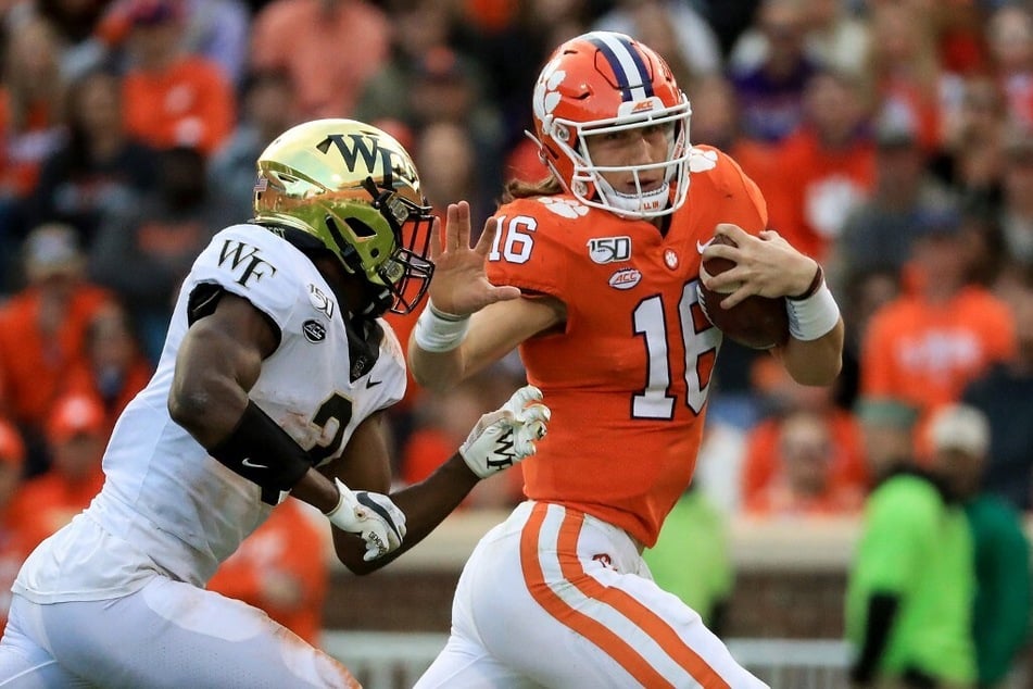 Nasir Greer (l) of the Wake Forest Demon Deacons goes after Trevor Lawrence of the Clemson Tigers during a conference game at Memorial Stadium.