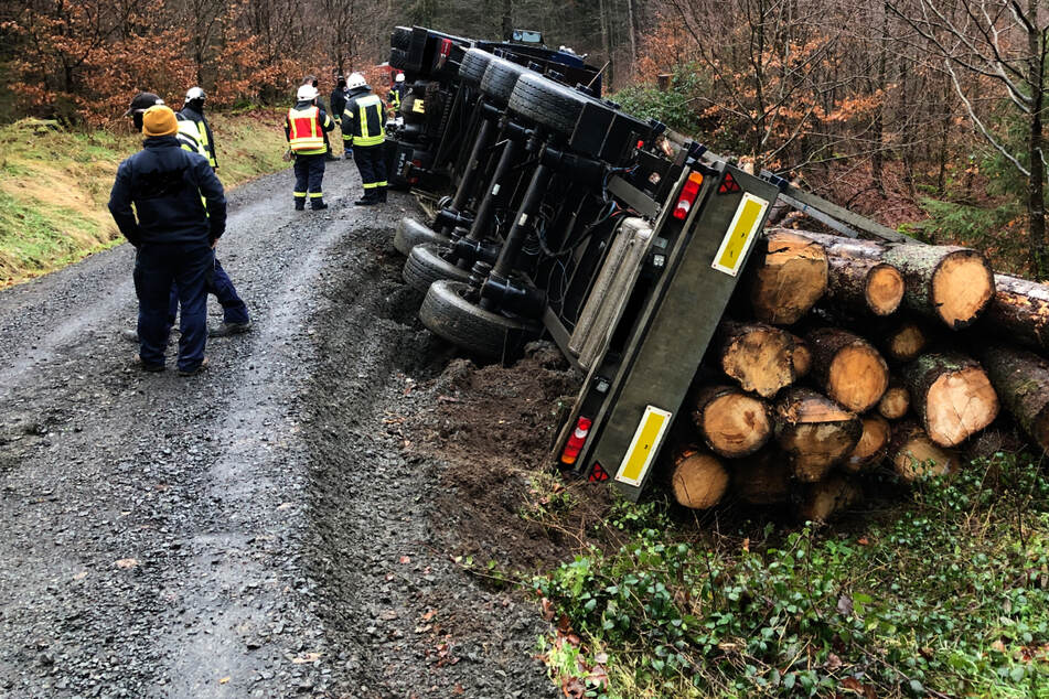 Holztransporter kippt auf schlammigem Weg um: Fahrer schwer verletzt
