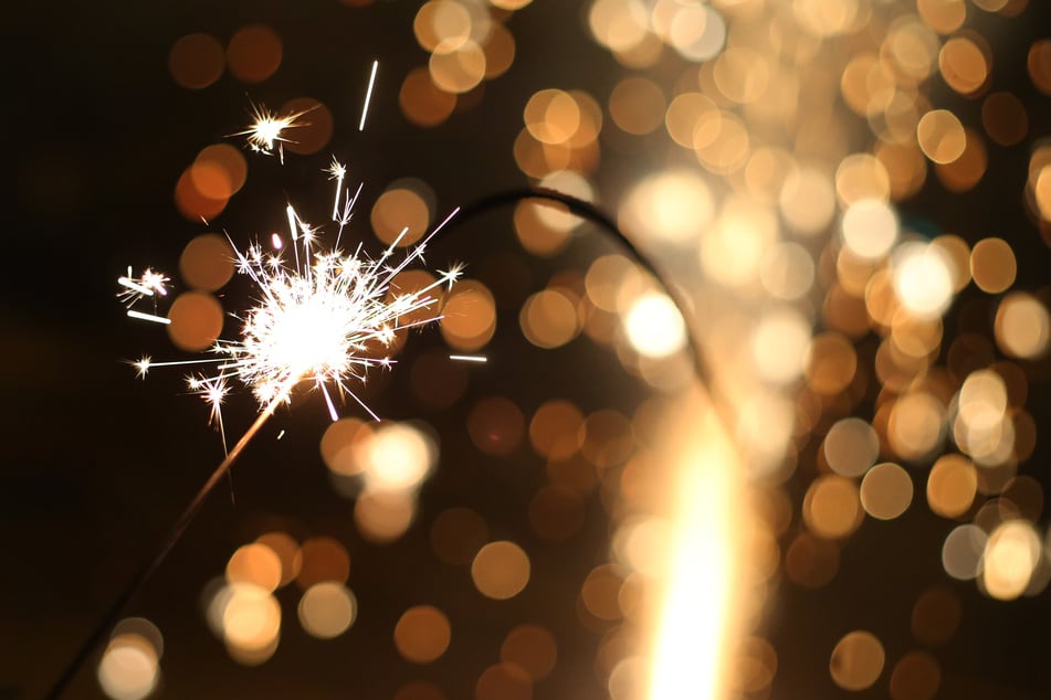 Eine große Wunderkerze brennt in der Silvesternacht.