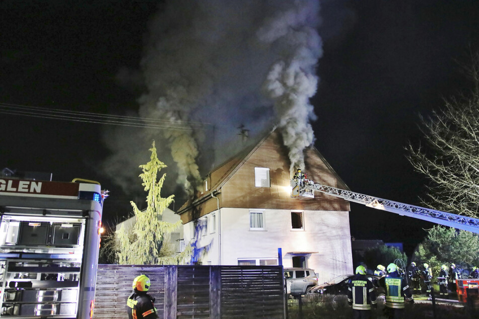 Feuerwehrleute löschen den Brand in einem Haus.
