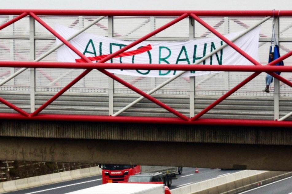 Ein Umweltaktivist hängt am 27. November an einer Brücke über der Autobahn A 7 bei Kassel.