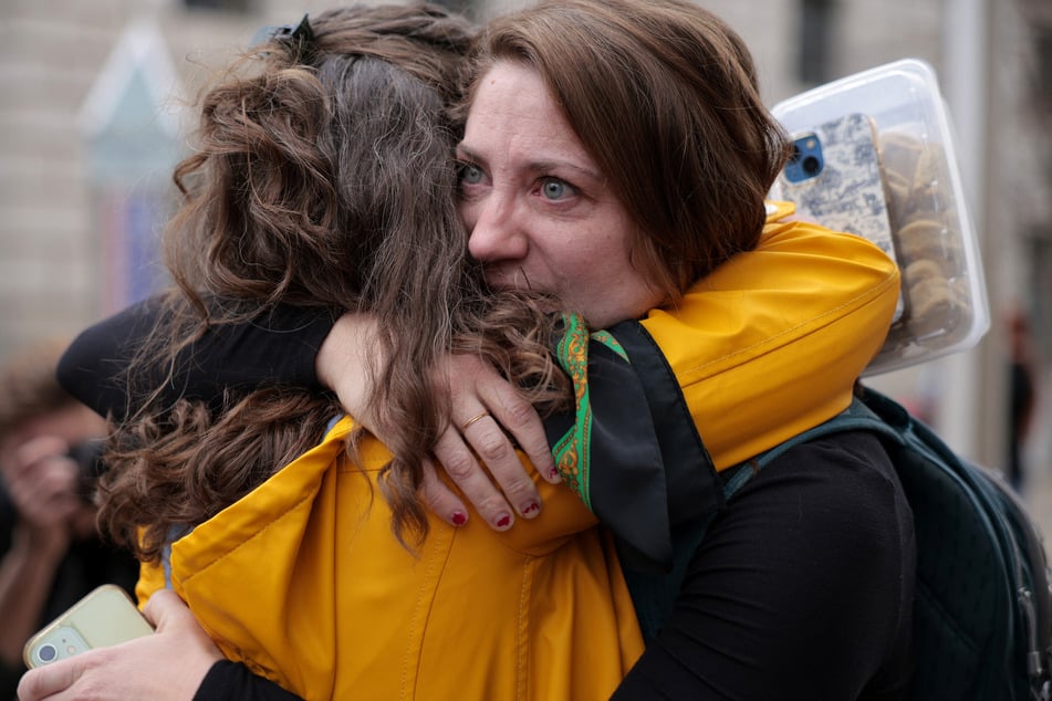 Former United States Agency for International Development (USAID) Africa Bureau employee Caitlin Harwood is embraced by her cousin Samantha Kent as Harwood arrived at USAID headquarters to collect her personal belongings on Thursday in Washington, DC.