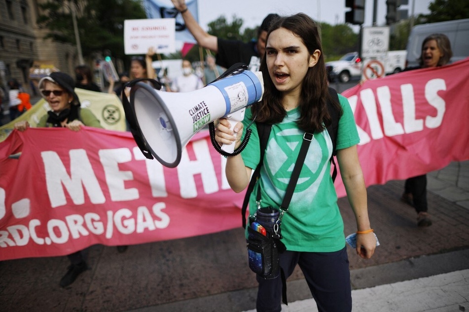 Protesters carry a banner reading "Gas Leaks, Methane Kills" while calling for a shift to renewable sources of energy during a march in Washington DC.