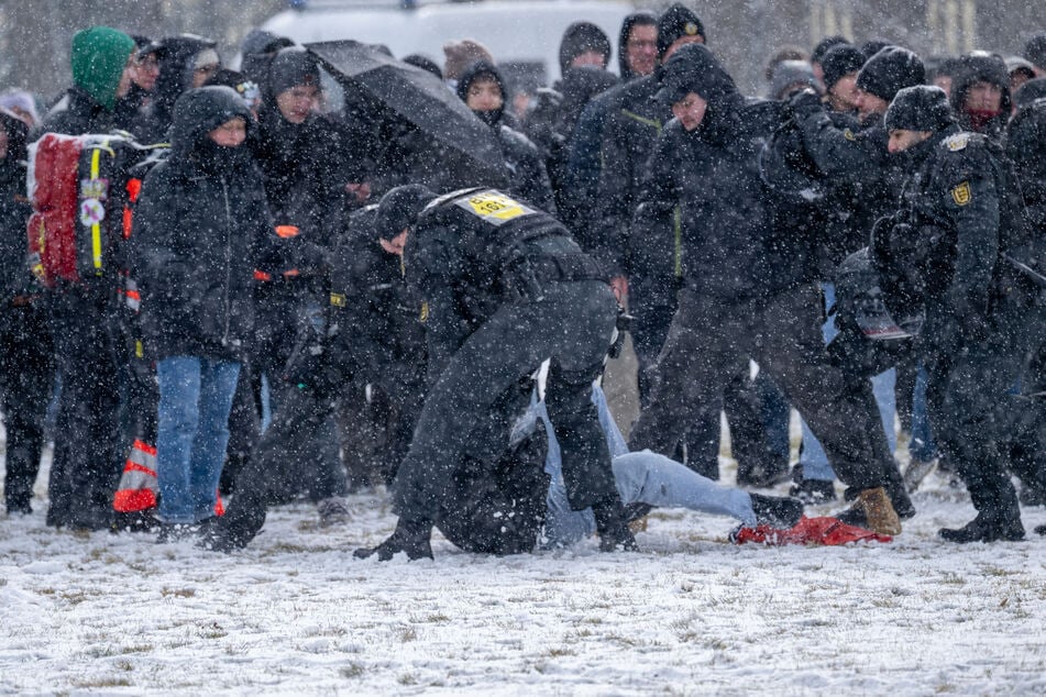 Ein Polizist nimmt einen Demo-Teilnehmer auf dem Königsplatz fest.