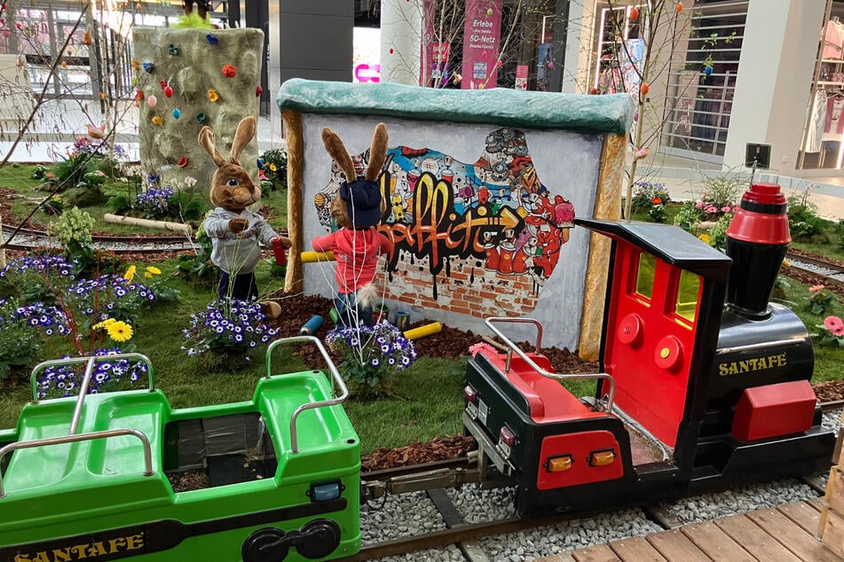 Kinder können auf einer Eisenbahn um die Kulisse düsen.