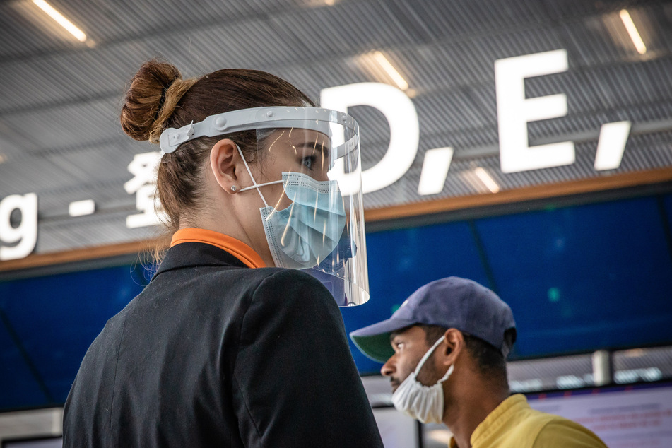 Eine Mitarbeiterin trägt Mundschutz und Gesichtsvisier, um sich vor einer Ansteckung mit dem Coronavirus zu schützen.