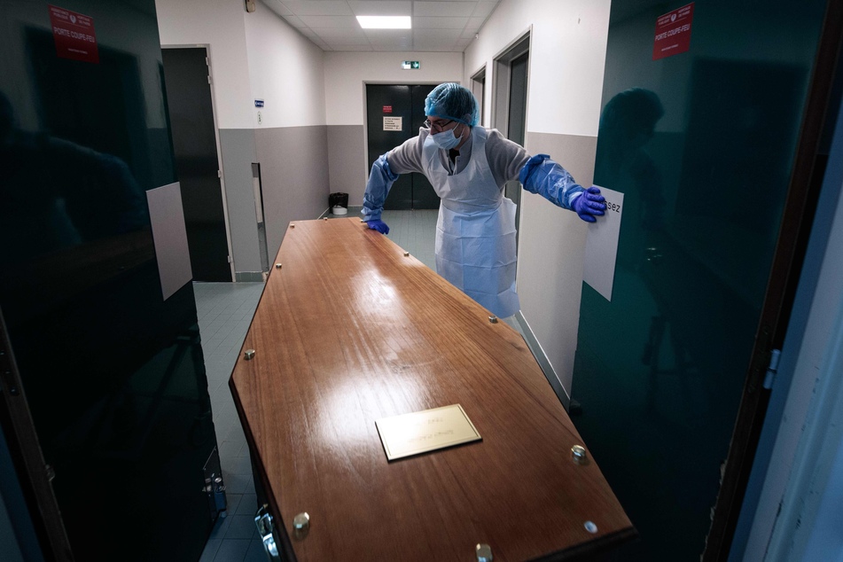 Ein medizinischer Mitarbeiter des Bichat-Claude-Bernard-Krankenhaus in Paris schiebt einen Sarg zur Vorbereitung in einen Trauerraum, damit sich die Familie von ihrem Angehörigen verabschieden kann.