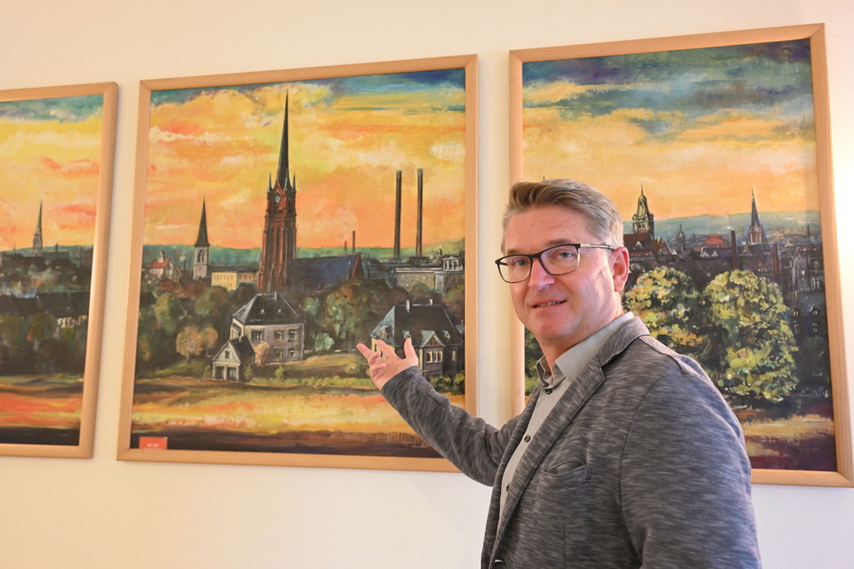 Andreas Knoth (56) zeigt im Seniorenheim SenVital auf das Gemälde mit der St.-Nikolaikirche.