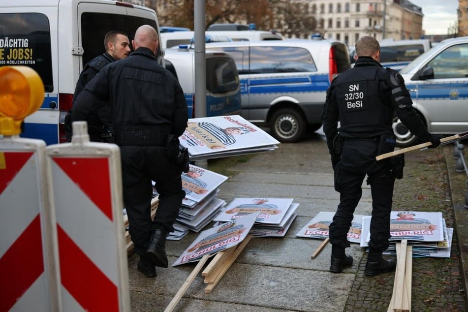Die Polizei stellte mehrere Plakate mit Abbildungen deutscher Politiker und Politikerinnen sicher.