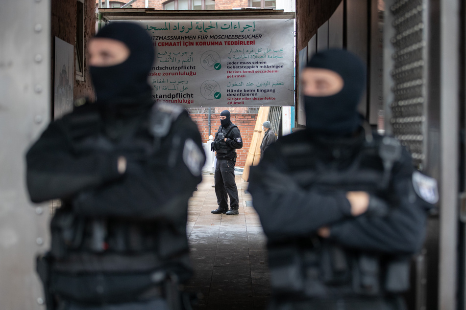Polizisten stehen am Eingang einer Moschee. (Symbolbild)