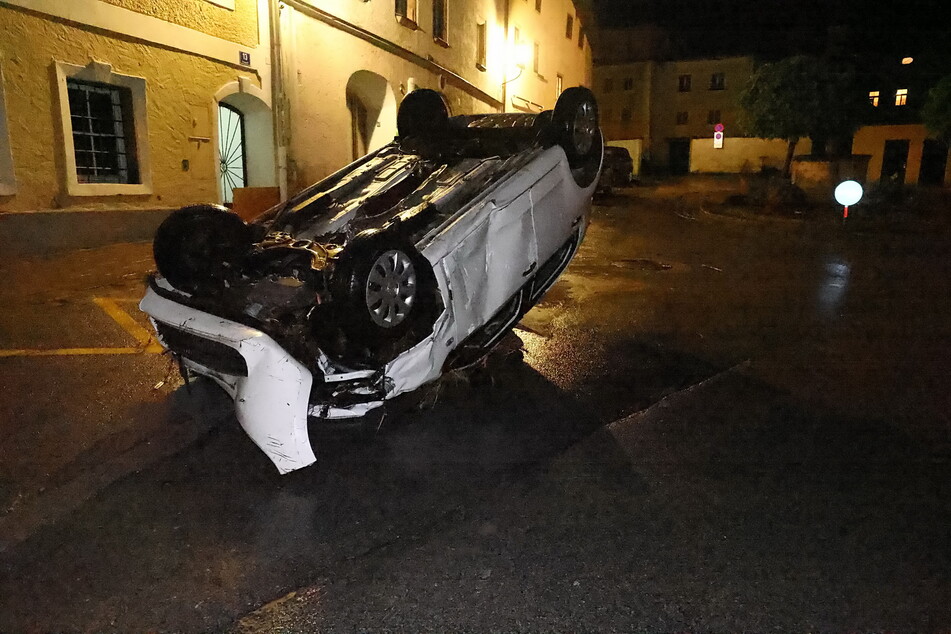 Ein Auto wurde von den Fluten in der Stadt Hallein mitgerissen und kam kopfüber auf der Straße zum Erliegen.
