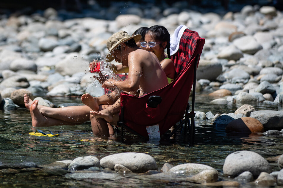 Drei Teenager kühlen sich im kalten Wasser des Lynn Creek ab. In einer Hitzewelle im Westen Kanadas haben die örtlichen Behörden die höchste Temperatur in der Geschichte des nordamerikanischen Landes gemessen.