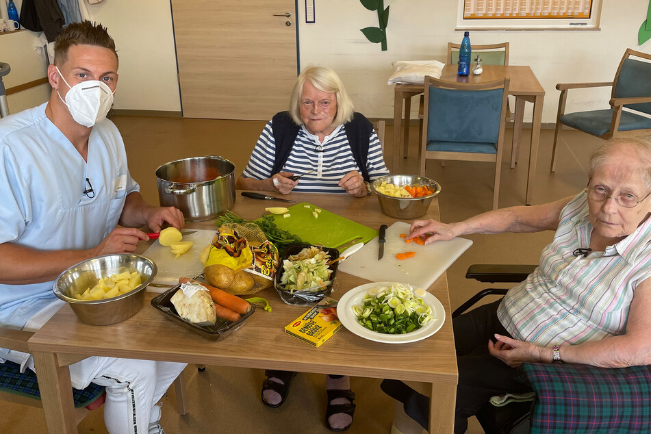 Calvin Kleinen (29) bekommt bei der Essenszubereitung Unterstützung von Karolina Reichart (91, M.) und Margarete Freiin von Gregory (84, r.)