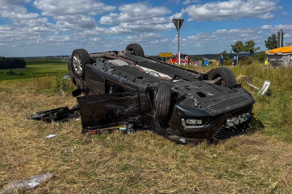 Ein Ford Mondeo ist nach einem Zusammenstoß mit einem Lkw auf einem Feld gelandet - kopfüber.