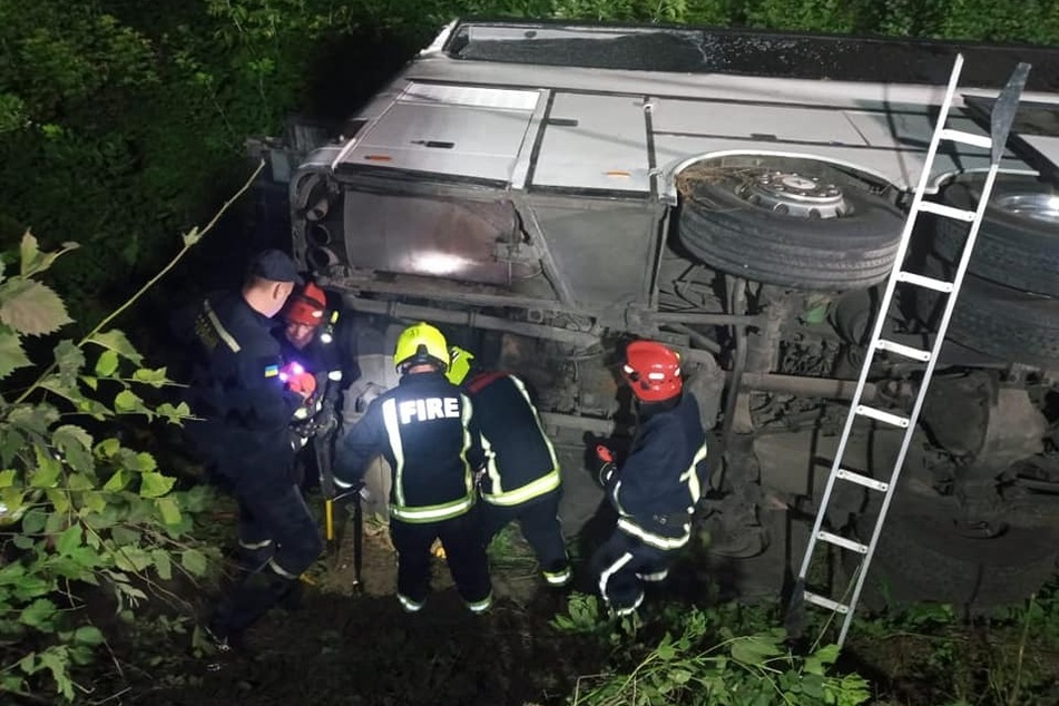 Einsatzkräfte begutachten den Bus, der in der Ukraine verunglückte.