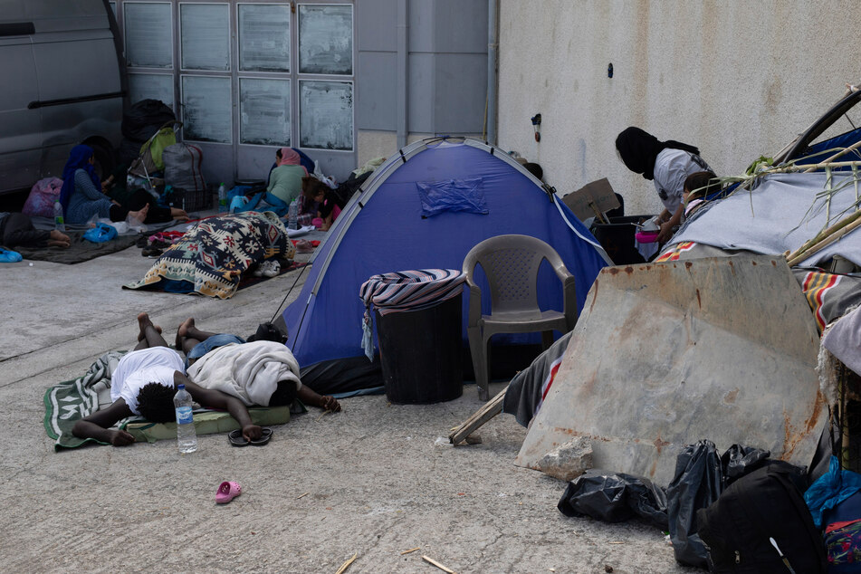 Migranten schlafen nach dem Feuer in einem provisorischen Zeltlager.
