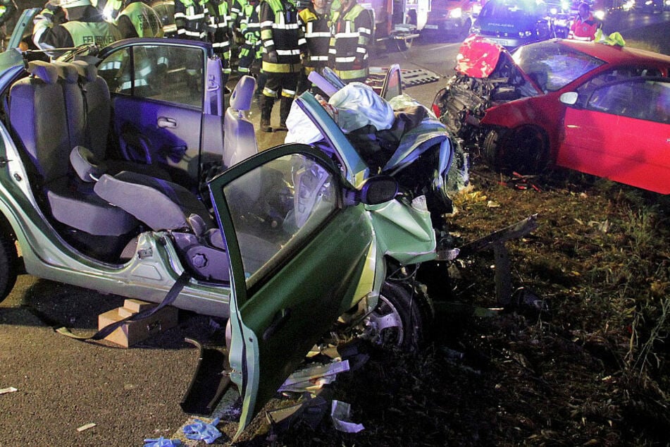 Rettungskräfte und zwei zerstörte Autos stehen an einer Unfallstelle. Bei dem Unfall starben zwei Frauen, zwei wurden schwer verletzt. (Archivbild)