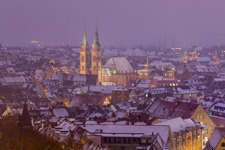 Die schnebedeckte Nürnberger Altstadt mit der Kirche St. Sebald (Sebalduskirche) zur blauen Stunde.
