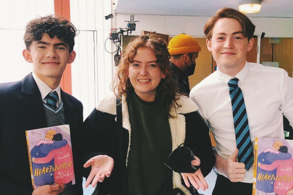 Author Alice Oseman (c.) celebrated the release of Heartstopper Volume 4 on the set of the Netflix adaption with stars Joe Locke (l.) and Kit Connor.