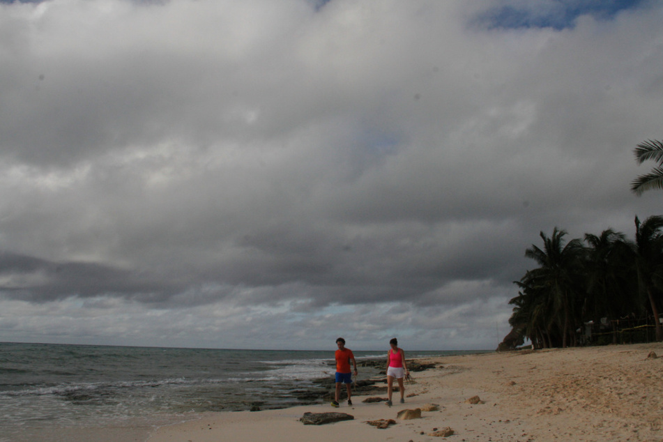 Ein Mann und eine Frau am Strand in der Nähe von Playa del Carmen. Hurrikan Delta verstärkte sich am Dienstag schnell zu einem Hurrikan der Kategorie zwei.