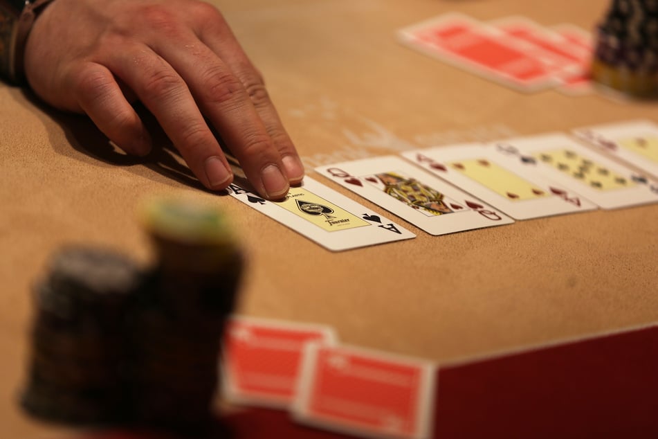 Ein Croupier teilt am Pokertisch Karten aus. (Symbolfoto)