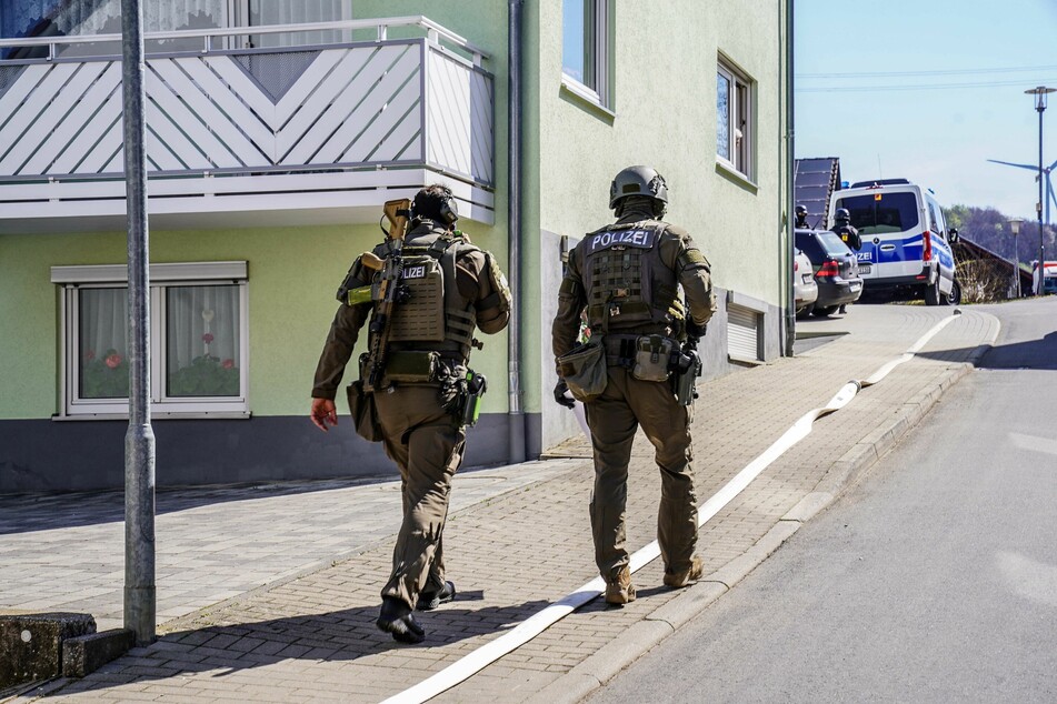 Schwer bewaffnete Spezialeinsatzkräfte gehen durch Boxberg-Bobstadt.