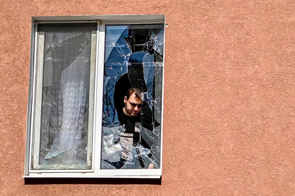 Ein Mann in der Region Belgorod betrachtet das zerbrochene Fenster seines Hauses nach dem Beschuss durch die Ukraine.