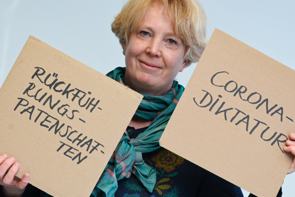 Nina Janich, Sprachwissenschaftlerin an der TU Darmstadt und Sprecherin der Jury der sprachkritischen Aktion "Unwort des Jahres", hält in ihrem Institut zwei Pappschilder mit den Aufschriften "Rückführungspatenschaften" und "Corona-Diktatur".