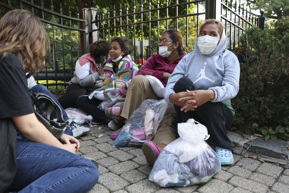 Migrants from Central and South America wait near the residence of US Vice President Kamala Harris after being dropped off in buses on September 15, 2022.