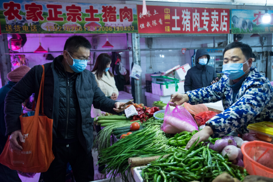China, Wuhan: Bürger kaufen Gemüse auf einem Markt.