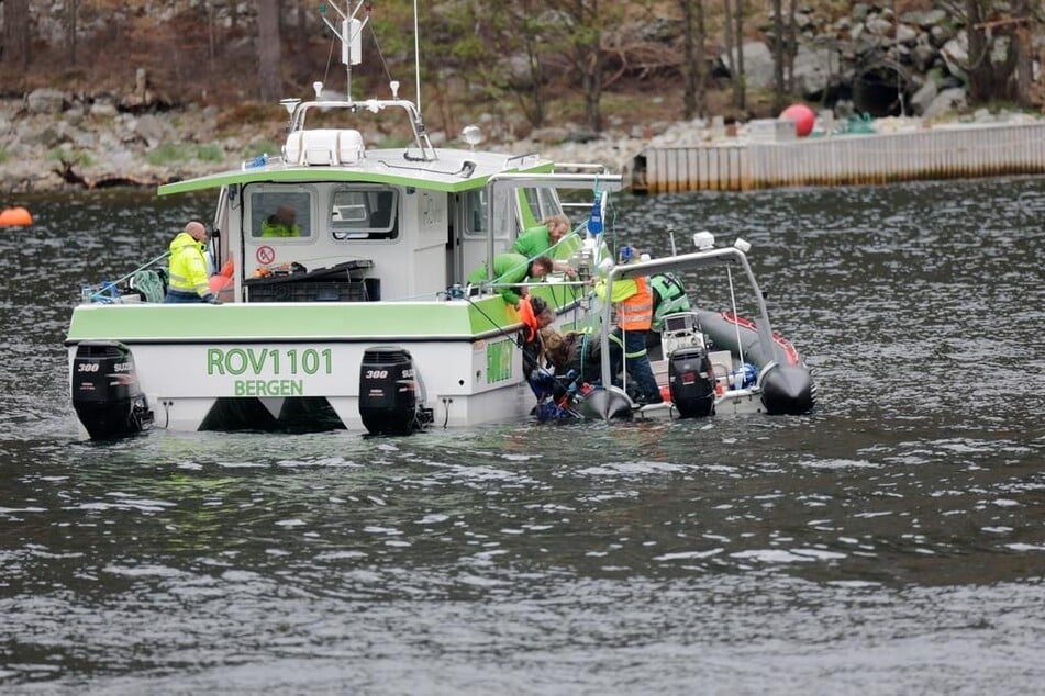 Hier wird die Leiche der Frau aus dem Fjord auf ein Boot geholt.