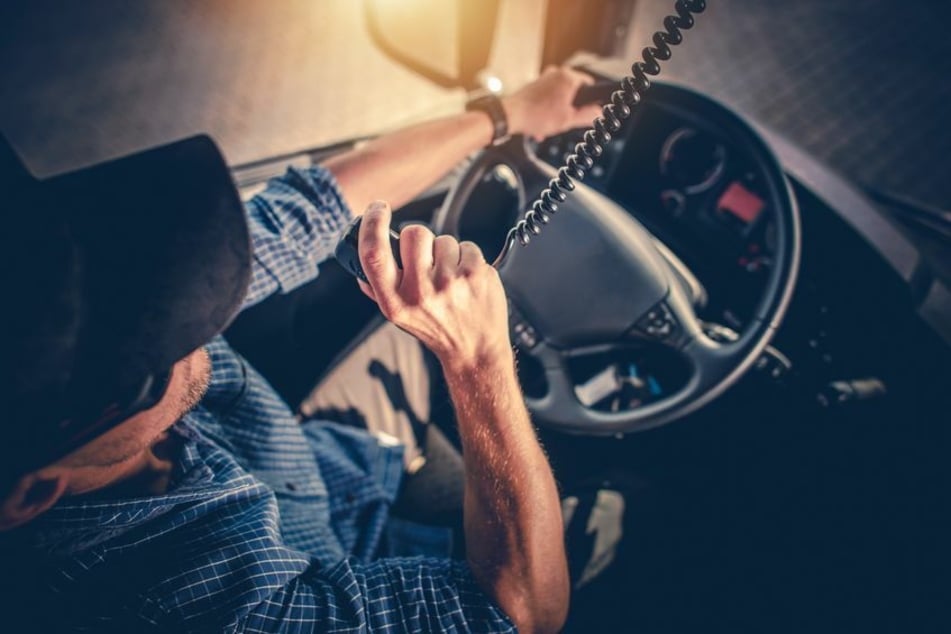 Ein Lkw-Fahrer spricht in sein Funkgerät. (Symbolbild)