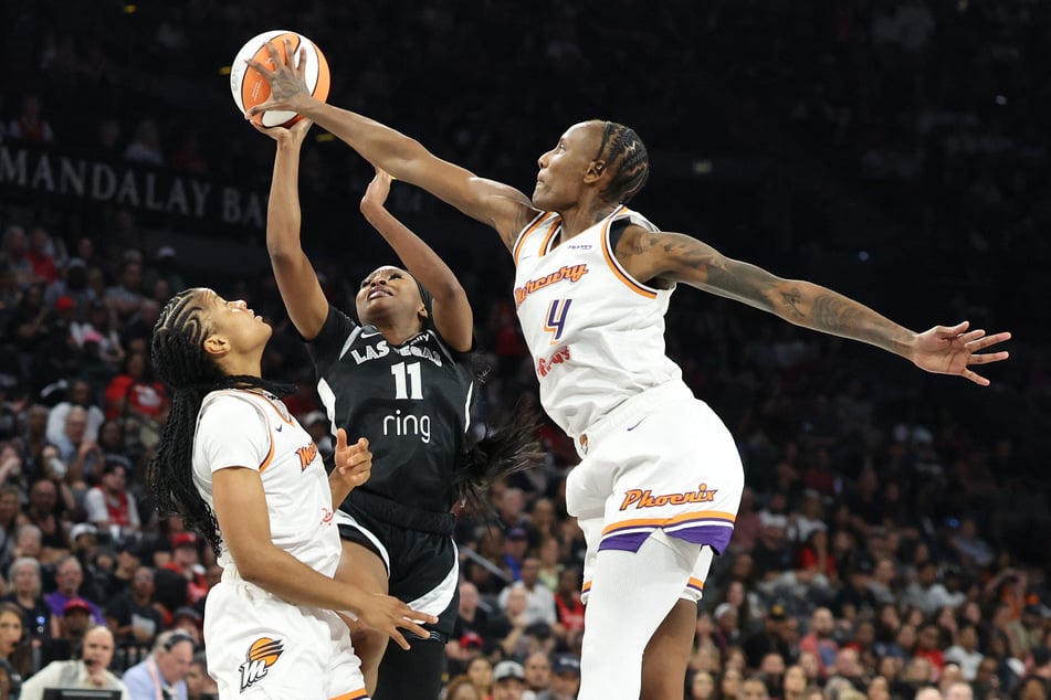 Dana Evans (c.) of the Las Vegas Aces shoots the ball between Monique Akoa Makani (l.) and Natasha Mack of the Phoenix Mercury in the second quarter of Game One of the 2025 WNBA Finals at Michelob ULTRA Arena on October 3, 2025.