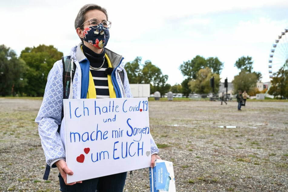 Karoline Preisler, FDP-Politikerin aus Mecklenburg-Vorpommern, steht mit einem Schild "Ich hatte Covid 19 und mache mir Sorgen um Euch" am Rande des Gottesdienstes der "Querdenker", der am Ufer des Bodensees gefeiert wird.