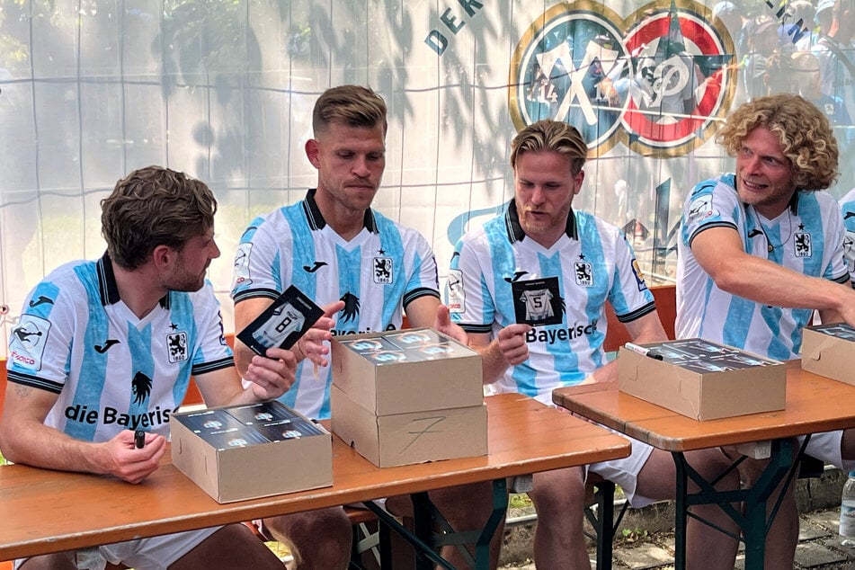 Die Spieler David Philipp, Florian Niederlechner, Thore Jacobsen und Jesper Verlaat (v.l.n.r.) schreiben beim Fanfest Autogramme.