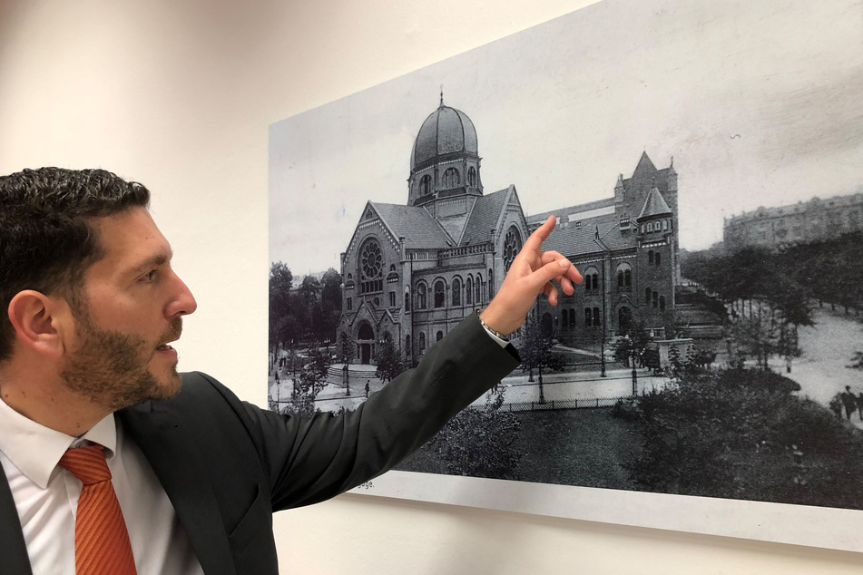Philipp Stricharz zeigt auf ein historisches Foto der Bornplatzsynagoge.