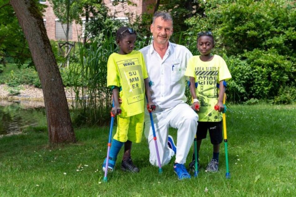 Dr. Ulf Kilian freut sich gemeinsam mit den "Friedensdorf"-Kindern Sankung (l.) und Abobakr über die guten Behandlungsergebnisse.