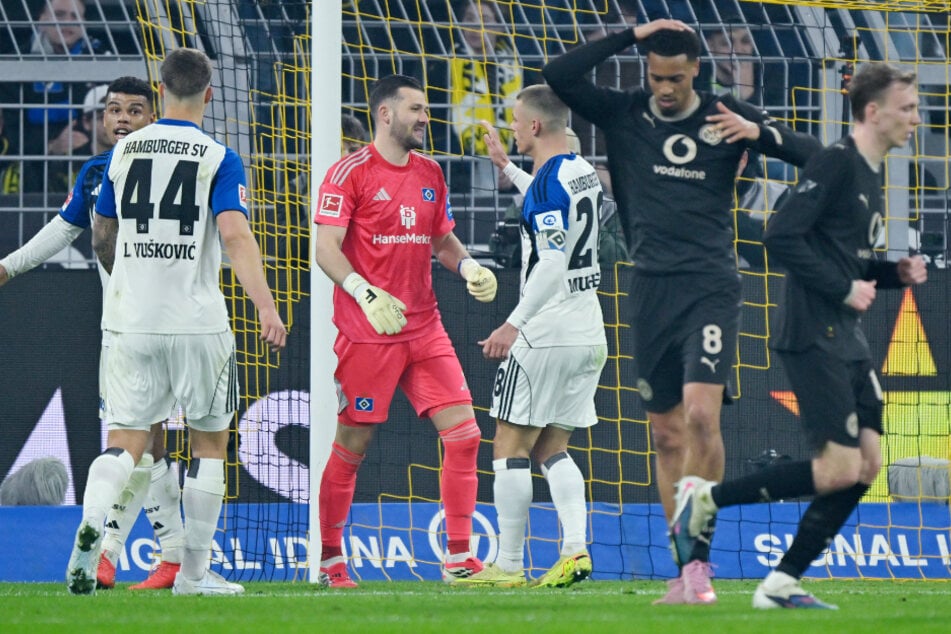 BVB-Profi Felix Nmecha (2.v.r.) hält sich nach seinem verschossenen Elfmeter den Kopf, während die HSV-Profis jubeln.