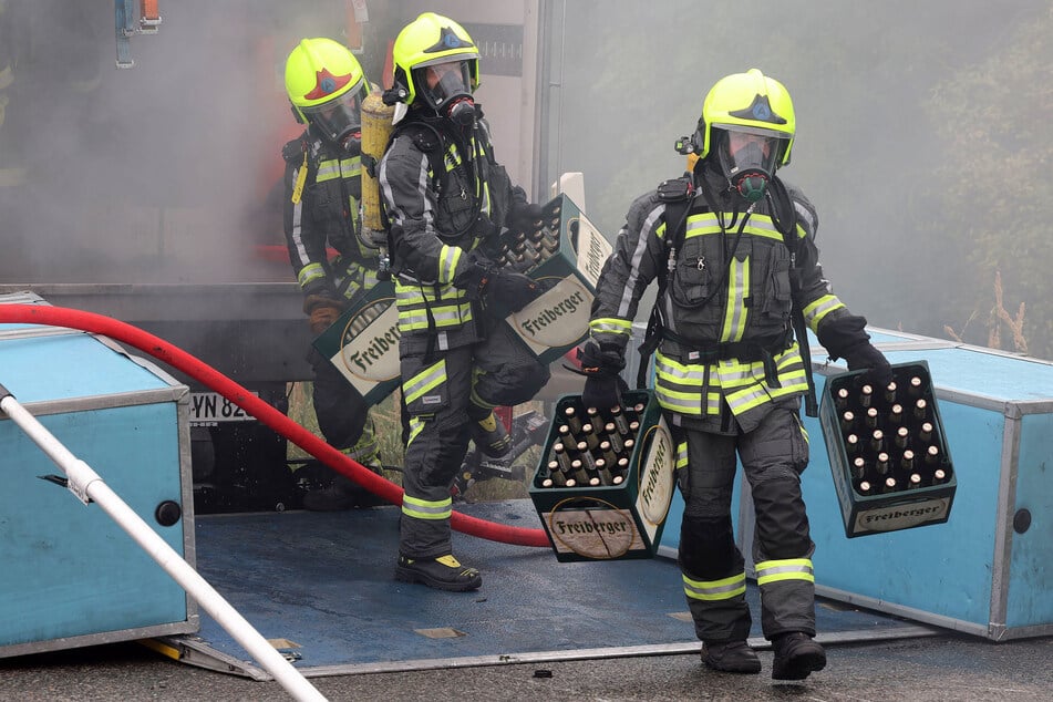 Die Feuerwehrleute räumten während des Einsatzes mehrere Kästen Bier vom Laster.