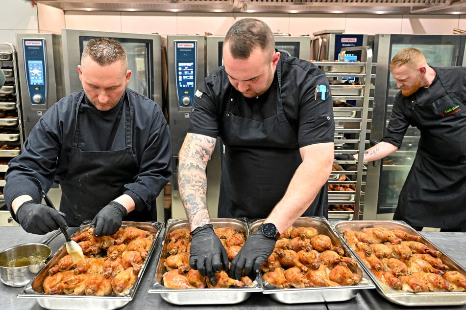 Zwei "Chefs de Parties" pinseln die Enten mit Honig ein.