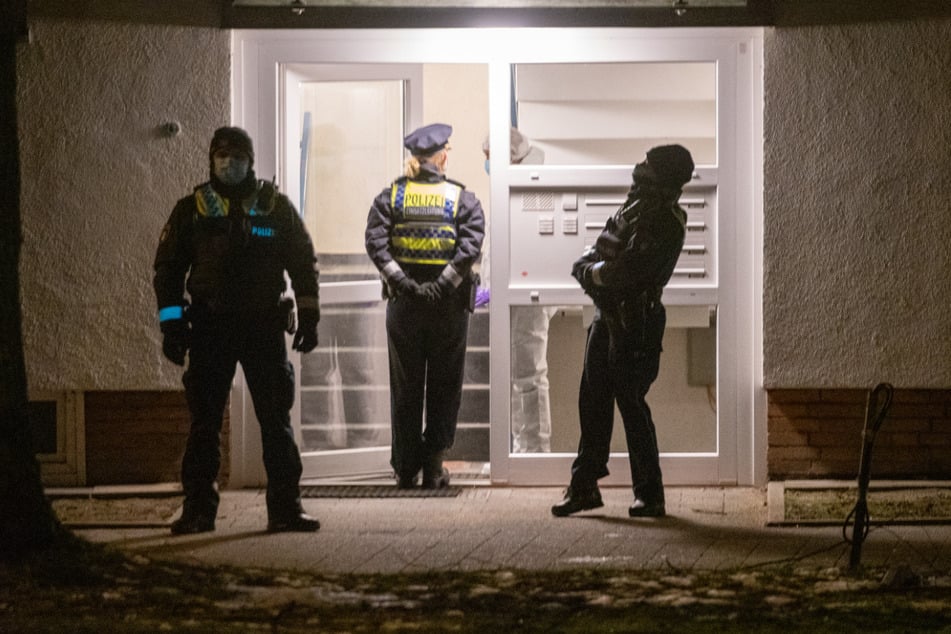 Polizisten vor einem Mehrfamilienhaus in Hamburg.