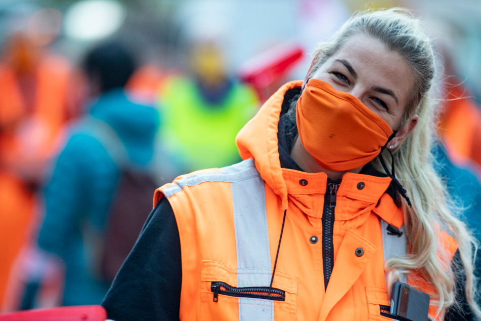 Eine Mitarbeiterin der Hamburger Stadtreinigung steht bei einer Kundgebung der Gewerkschaft Verdi zu Warnstreiks im öffentlichen Dienst auf dem Jungfernstieg. Nun ruft verdi auch Beschäftigte von Krankenhäusern zum Streik auf.