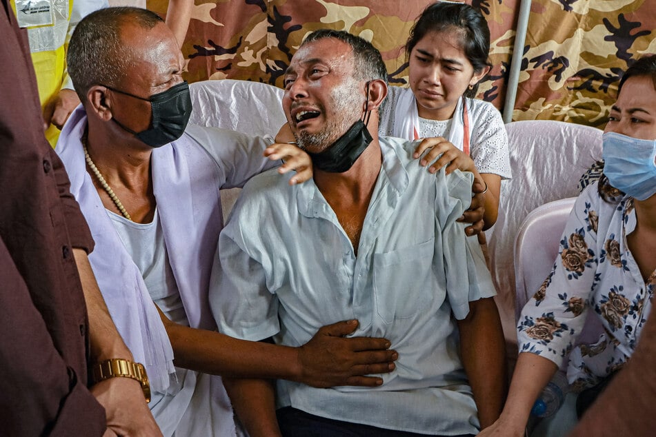 Mourners console Kongbrailatpam Nandeshkumar Sharma (2L), father of plane crash victim Kongbrailatpam Nganthoi Sharma, a cabin crew member of the Air India flight AI171, during her funeral ceremony in Imphal on Sunday.