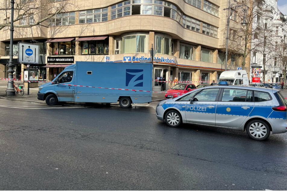 Geldtransporter und Polizeiwagen stehen vor der Filiale der Berliner Volksbank am Kurfürstendamm im Berliner Bezirk Charlottenburg-Wilmersdorf.