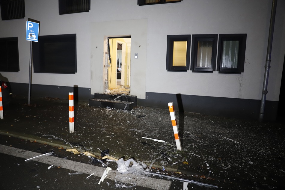 Scherben liegen vor einem Gebäude in Duisburg, nachdem Einsatzkräfte der Polizei bei einer Razzia die Tür aufgesprengt haben.